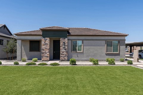 A modern house with a stone facade and a black door.