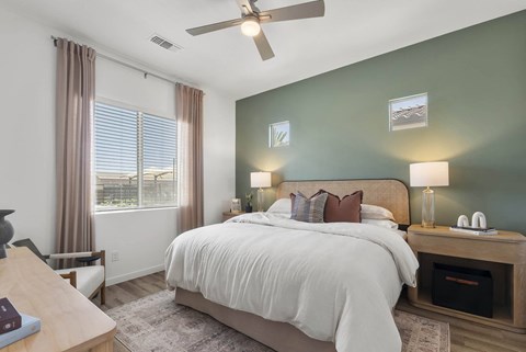 A bedroom with a large bed and a ceiling fan.