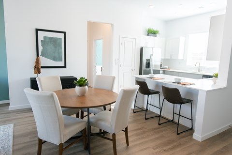 A modern dining room with a round table and chairs.