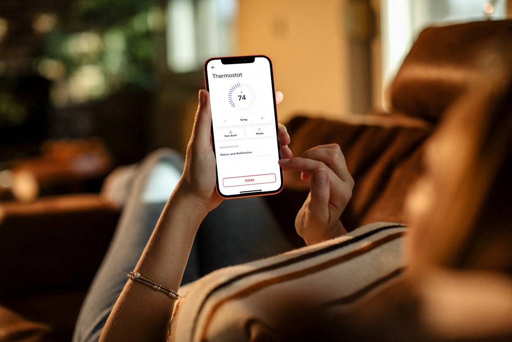 a woman holding up a cell phone with a screen displaying a user interface  at Avilla Centerra Crossings, Goodyear, AZ, 85338