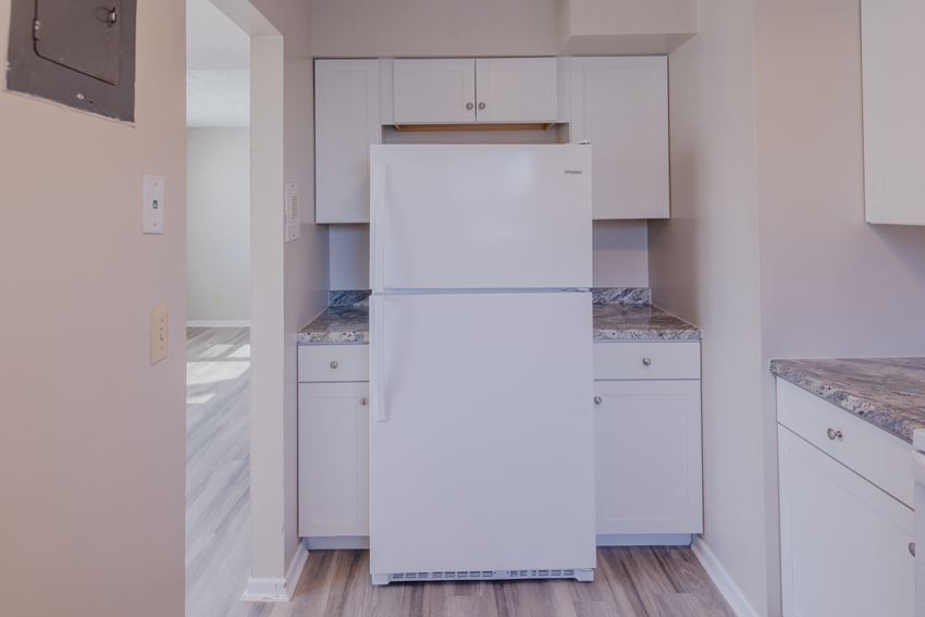 a white refrigerator in a kitchen with white cabinets