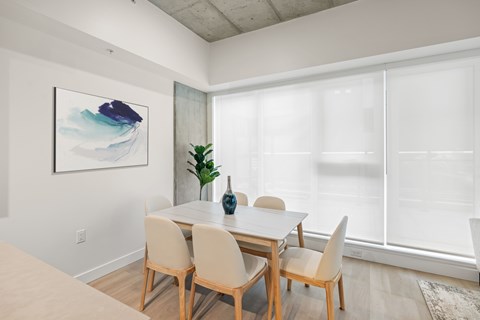 A dining room with a table and chairs.