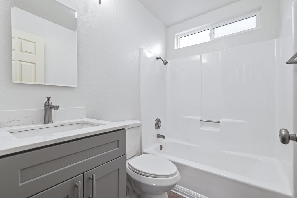 A white toilet sits next to a sink in a bathroom at Stony Creek Apartments, Santa Rosa