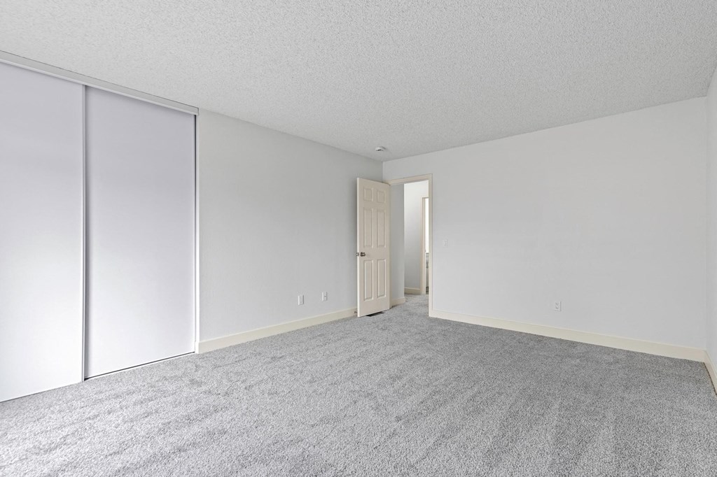 A room with a carpeted floor and a sliding door at Stony Creek Apartments, Santa Rosa, California