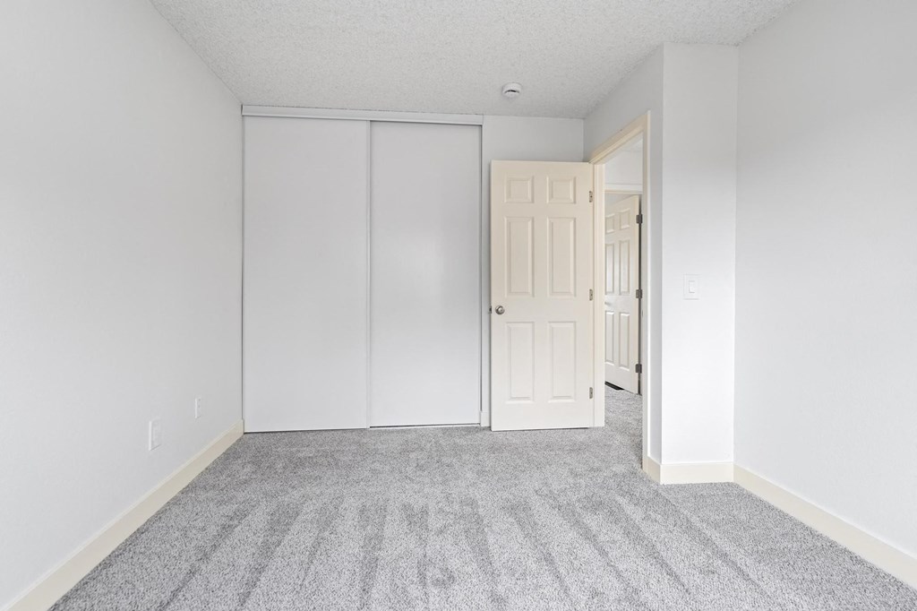 A room with a grey carpet and a white door at Stony Creek Apartments, Santa Rosa, 95401