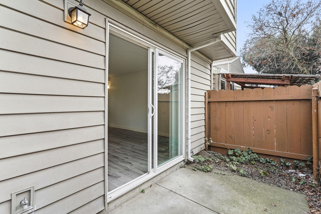A house with a white siding and a brown fence at Stony Creek Apartments, Santa Rosa