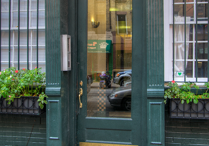 a view of a street through a green door