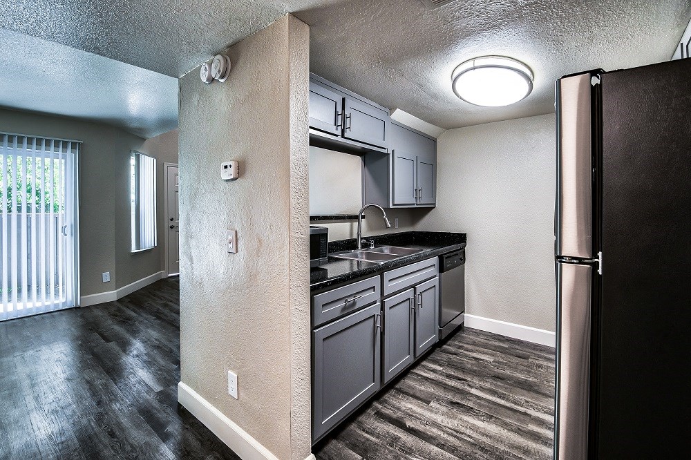 a kitchen with gray cabinets and black countertops