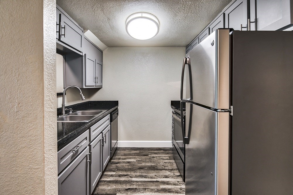 a kitchen with stainless steel appliances and a wooden floor