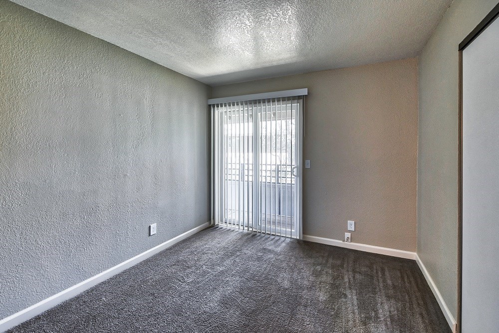 a bedroom with a sliding glass door and a carpeted floor