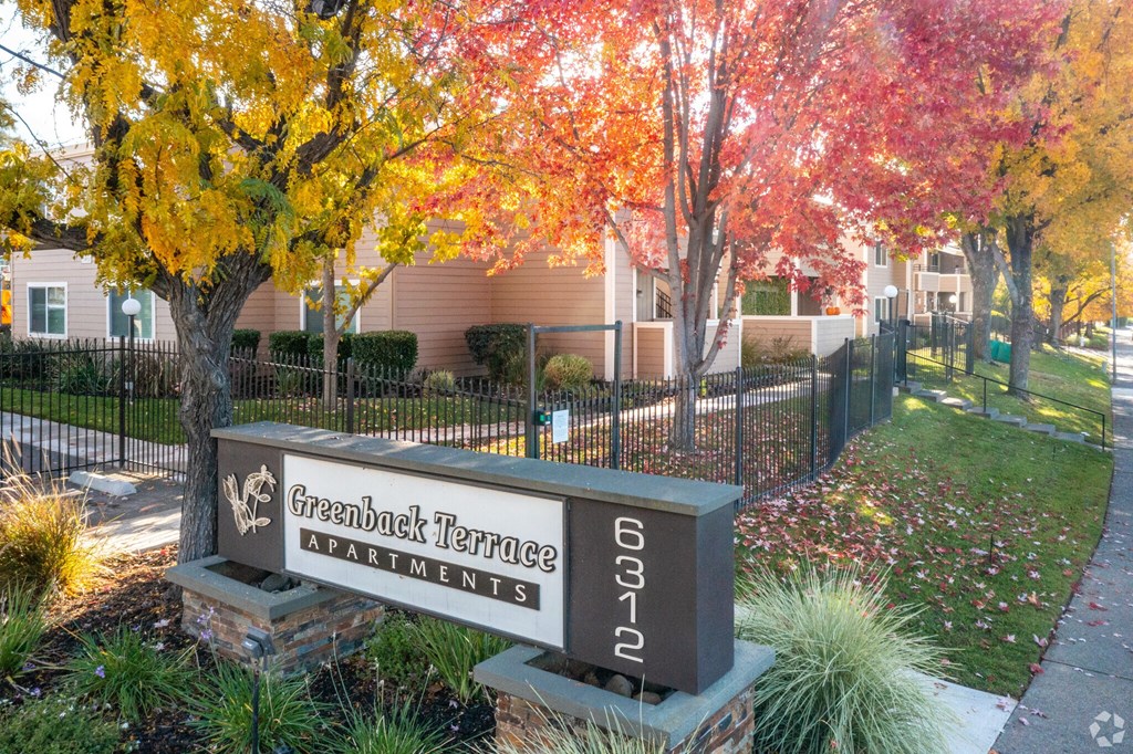 a building with a sign in front of some trees