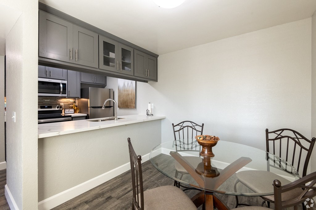a kitchen and dining room with a glass table and chairs