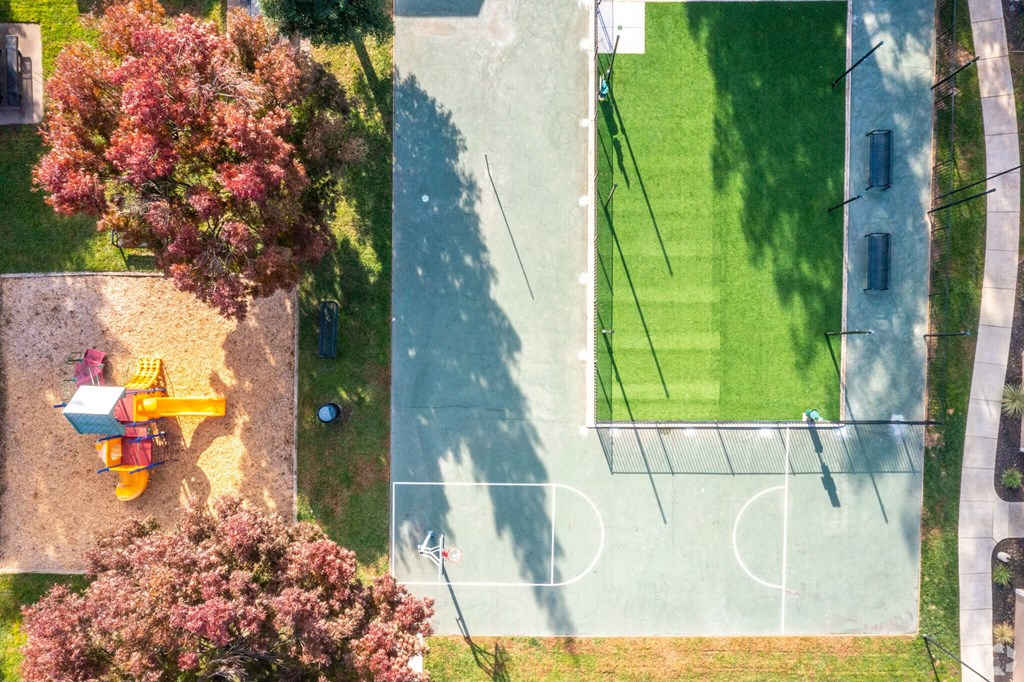 an aerial view of a park with a playground and trees