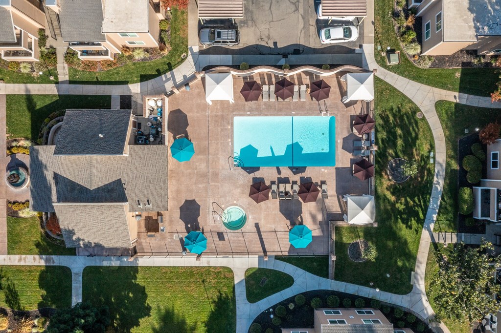 an aerial view of a house with a swimming pool and umbrellas