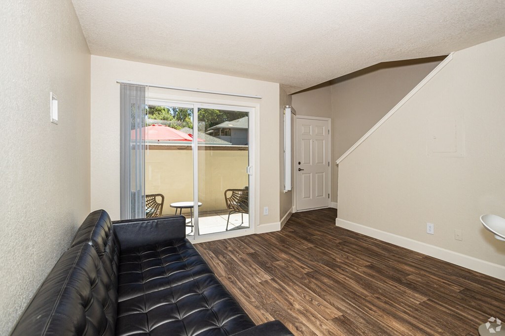 a living room with a couch and a sliding glass door to a balcony