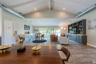 a living room with a large wooden table and a dining room