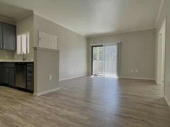 A room with wooden flooring and a window with blinds