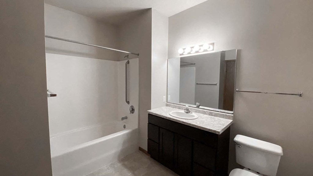 Modern master bathroom at Amber Crossing with marble counters, full shower, cupboards, and towel rack