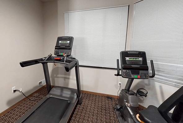 A newly renovated gym with a treadmill and row machine at Amber Crossing Apartments in Fargo, ND.