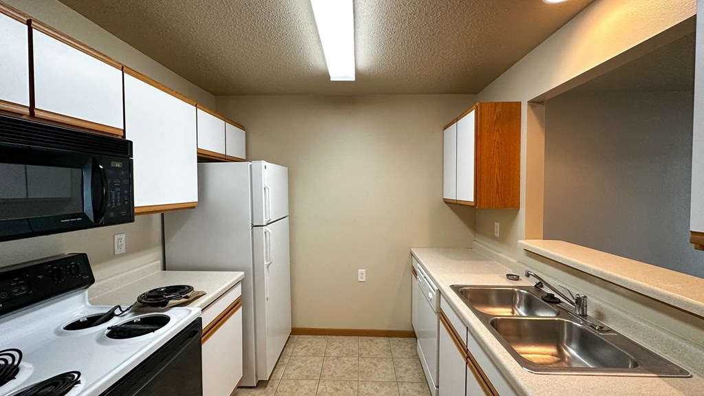 a kitchen with white cabinets and black appliances