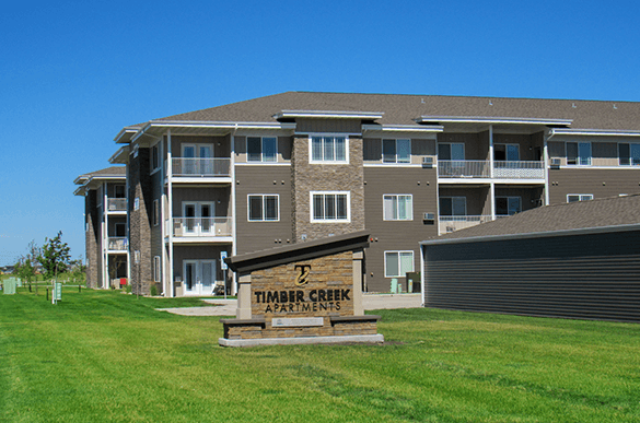 an apartment building with a sign in front of it