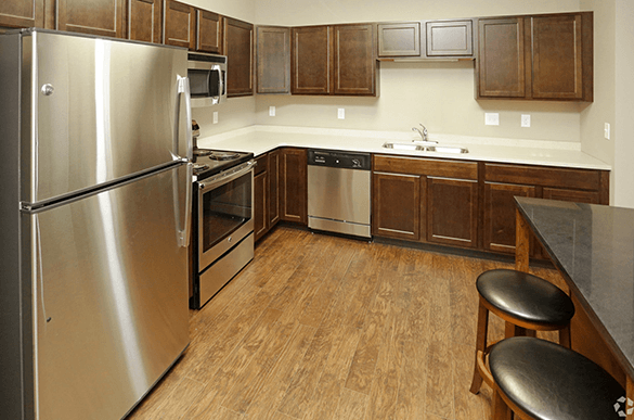 a kitchen with stainless steel appliances and wooden cabinets