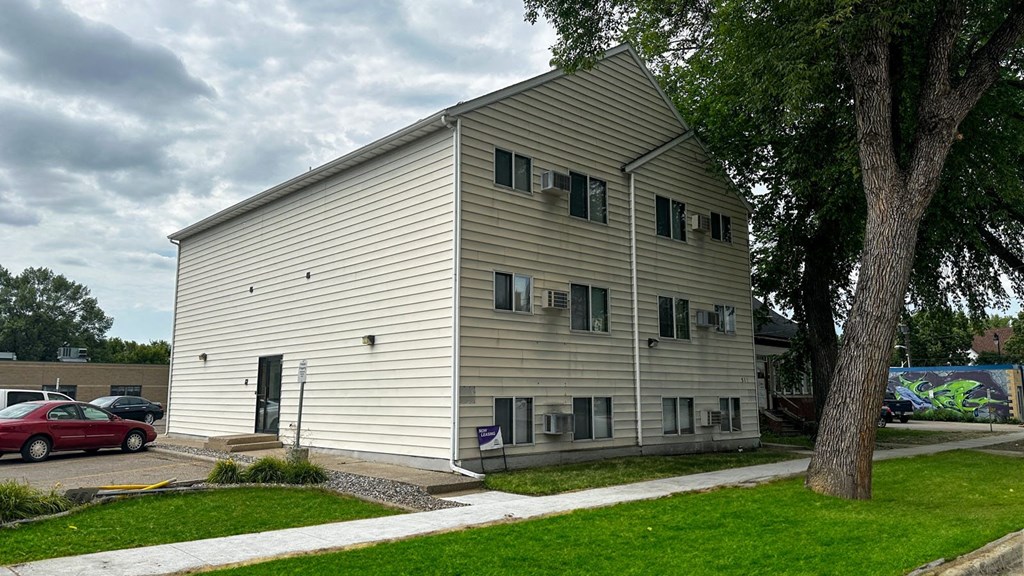 a large white building with a tree in front of it