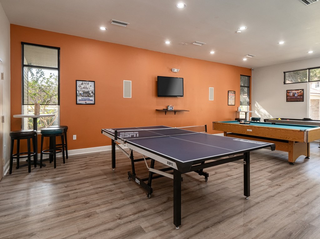 redesigned game room with two pool tables and a tv