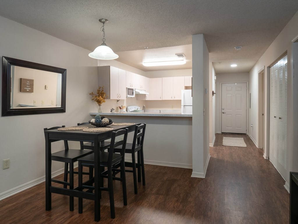a kitchen and a dining room with a table and chairs