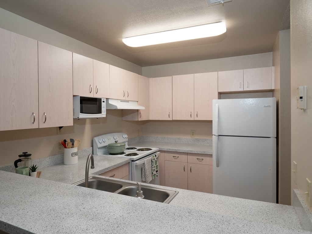 a kitchen with white cabinets and a sink and a refrigerator