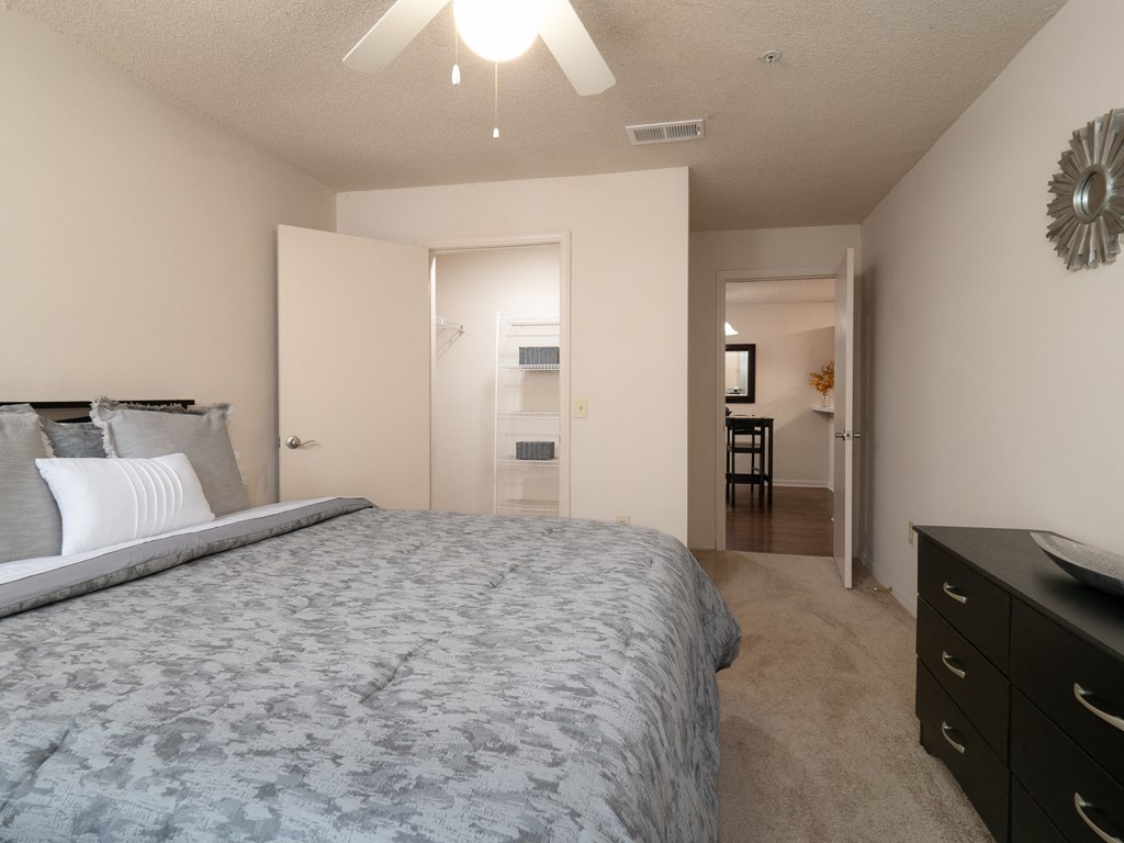a bedroom with a large bed and a view of a bathroom and a closet