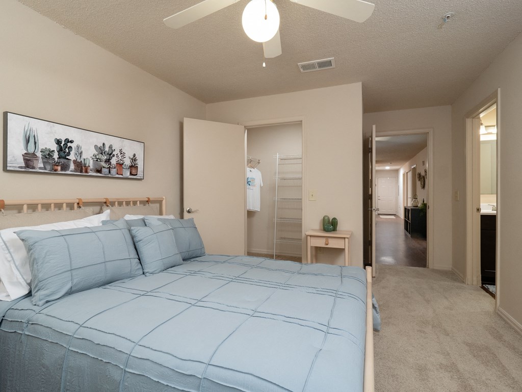 a bedroom with a bed and a closet and a ceiling fan