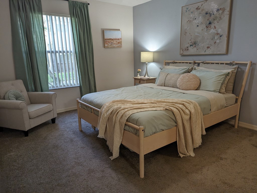 a bedroom with a bed and a chair and a window at Tivoli Apartments of Orlando, Oviedo, 32765