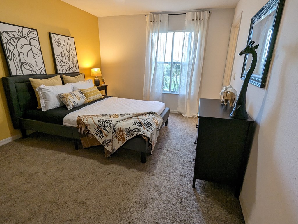 a bedroom with a bed and a dresser and a window at Tivoli Apartments of Orlando, Oviedo, Florida