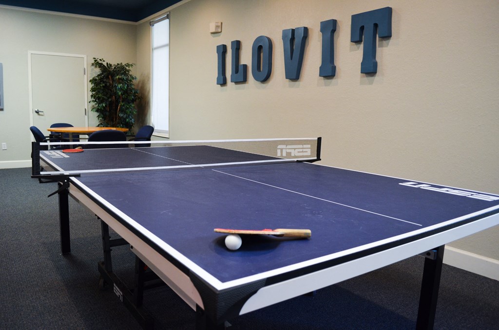 a blue ping pong table in a room with a scoreboard on the wall at Tivoli Apartments of Orlando, Oviedo, FL, 32765