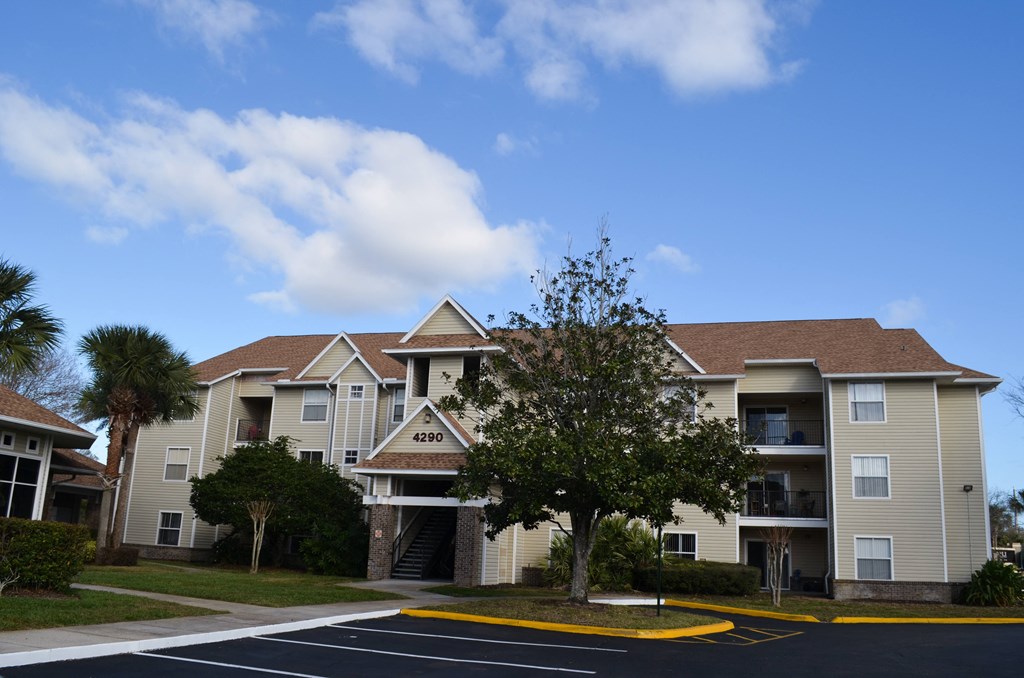 an apartment building with a tree in front of it at Tivoli Apartments of Orlando, Oviedo, 32765