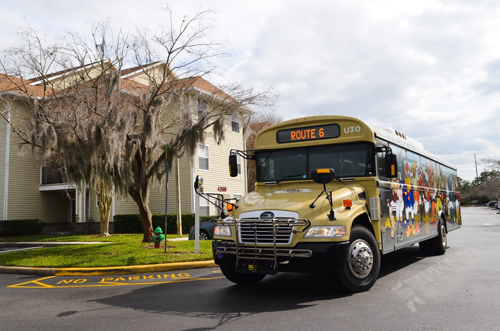 a school bus parked on the street in front of a house at Tivoli Apartments of Orlando, Oviedo, 32765