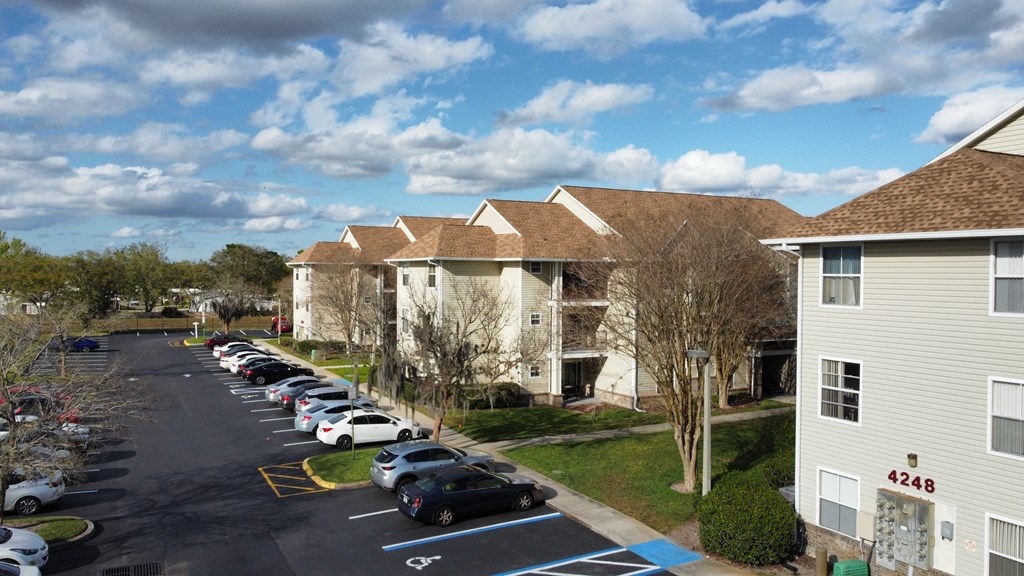 a row of houses with cars parked in a parking lot at Tivoli Apartments of Orlando, Oviedo, FL