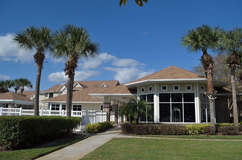 a house with palm trees in front of it at Tivoli Apartments of Orlando, Oviedo, Florida