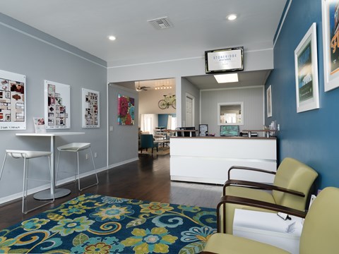 a leasing office with blue walls and a blue rug and a reception desk