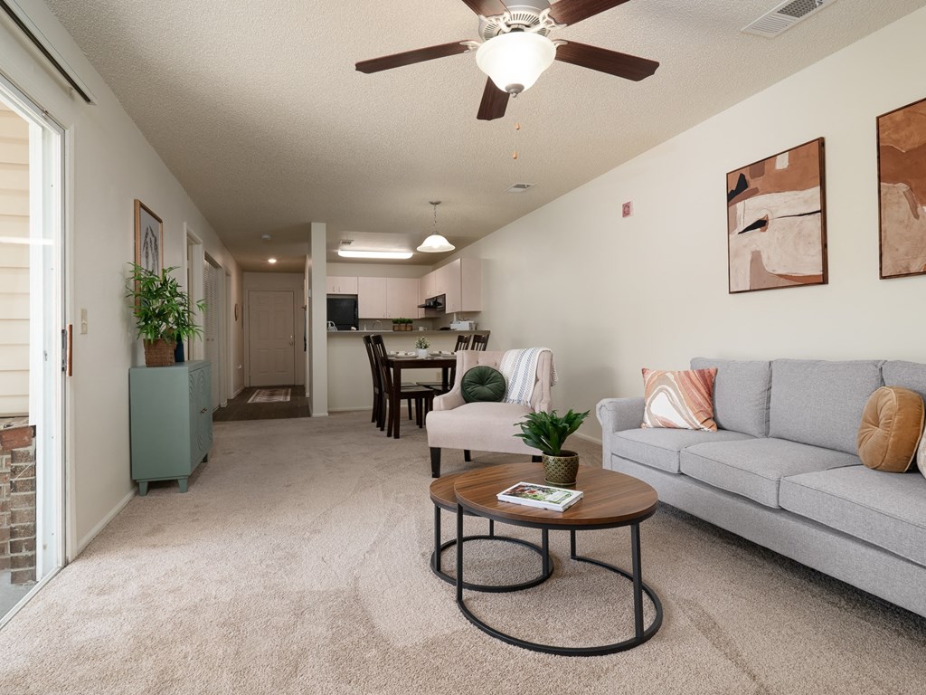 the living room and dining room of an apartment with a couch and a table at Stoneridge Apartments, Gainesville, Florida