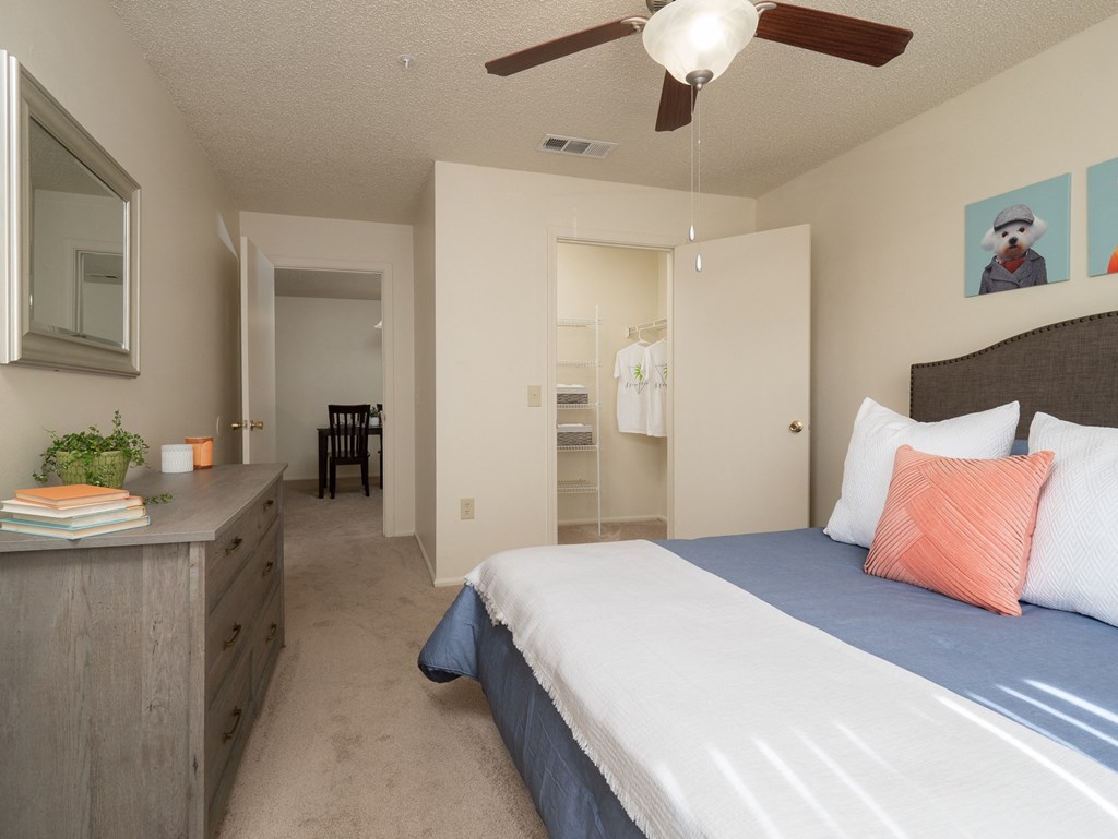 a bedroom with a bed and a dresser and a ceiling fan at Stoneridge Apartments, Gainesville, FL, 32608
