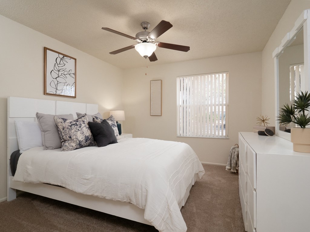 a bedroom with a large white bed and a ceiling fan at Stoneridge Apartments, Gainesville, FL