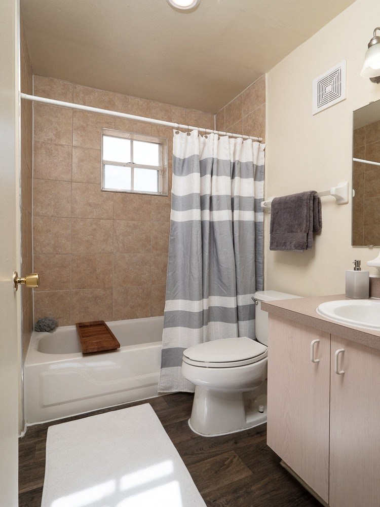 a bathroom with a toilet and a shower and a sink at Stoneridge Apartments, Gainesville, FL