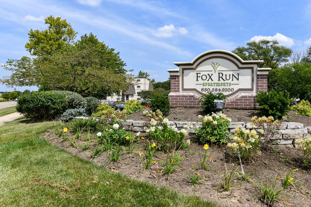 a garden with flowers in front of a fox run signat Fox Run Apartments, St. Charles, IL, 60174