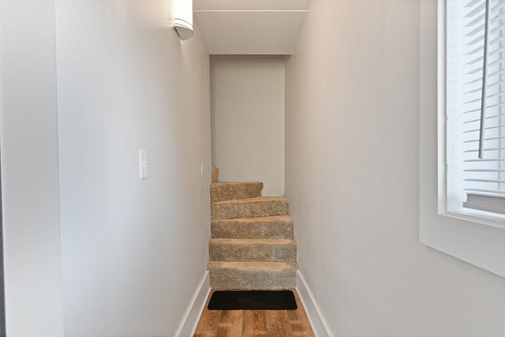 an empty staircase in a home with white walls and wood floorsat Fox Run Apartments, St. Charles, 60174