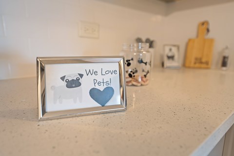 A picture frame with a dog and a heart and the words "We Love Pets!" on it.