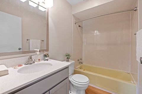 A bathroom with a sink, toilet, and bathtub.