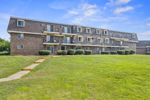 A large brick building with multiple balconies and windows.