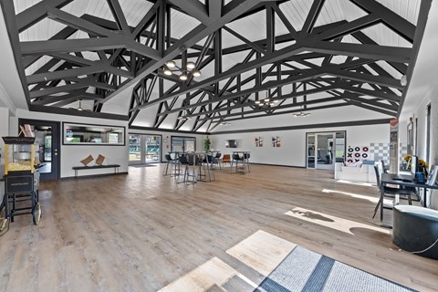 A spacious room with a high ceiling and wooden flooring.